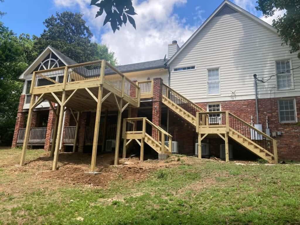 Custom deck and railing installation in Pelham, Alabama, with elevated stairs and backyard access.