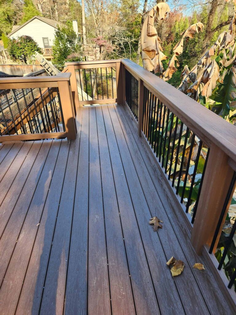 Composite deck with black metal railings overlooking a landscaped yard by Elite Decks, deck builder serving Alabaster, AL