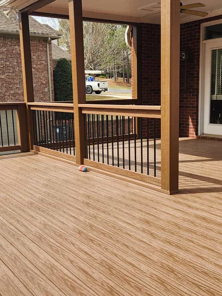 Covered deck with wood-look flooring and black railings by Elite Decks, deck builder serving Chelsea, AL