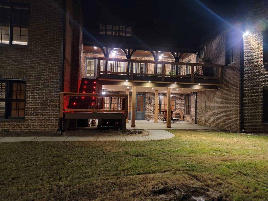 Custom deck and covered porch with evening lighting by Elite Decks, deck builder serving Cullman, AL